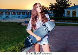 девушка держит в руках скейтборд черный на улице